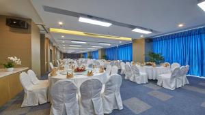 盘锦盘锦中心智选假日酒店的宴会厅配有白色的桌子和白色的椅子