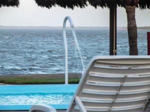 图托亚Pousada Jagatá的坐在游泳池旁的椅子,享有海景