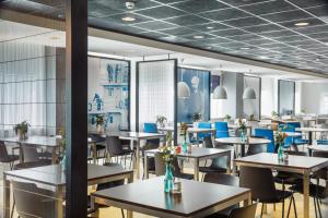 鹿特丹鹿特丹中央车站智选假日酒店的一间配备有桌子和蓝色椅子的用餐室