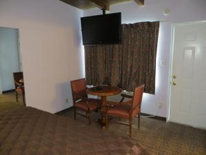 洛杉矶谢内加公园汽车旅馆的配有一张床和一张桌子及椅子的房间