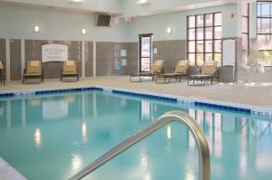 莫米Staybridge Suites Toledo/Maumee, an IHG Hotel的一个带椅子和桌子的大型游泳池