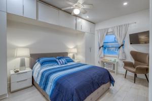 迈阿密海滩Ocean Drive Apartments的一间卧室配有一张带蓝色棉被的床和窗户。