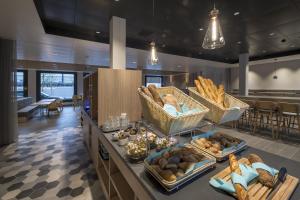 卢塞恩Holiday Inn Express - Luzern - Kriens, an IHG Hotel的自助餐,包括面包和柜台上的篮子食物