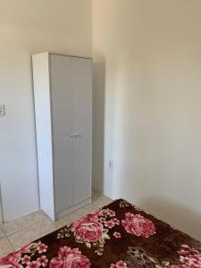 南圣洛伦索Ap beira da Praia das Ondinas的一间卧室配有一张床和一个铺有地毯的橱柜