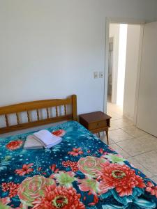 南圣洛伦索Apartamento beira da Praia das Ondinas的一间卧室配有一张带花卉毯子的床