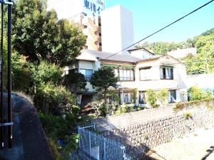 热海Guesthouse Nishihara的建筑前有围栏的房子