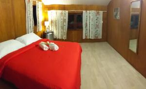 波拉波拉Matira house的卧室配有红色的床,里面装有两只动物