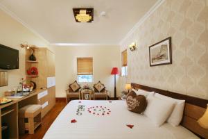 河内Hanoi House Hostel & Travel的一间酒店客房,床上摆放着红色鲜花