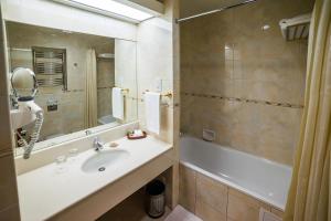 托木斯克玛吉斯切特酒店的一间带水槽、浴缸和镜子的浴室