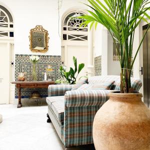 塞维利亚卡萨德科隆精品酒店的带沙发和盆栽植物的客厅