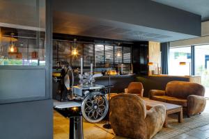 欧什Le Domaine de Baulieu的客厅配有椅子、桌子和机器