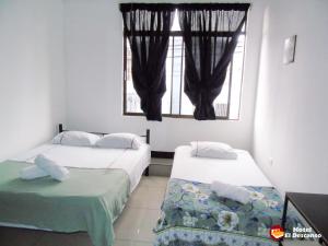 圣何塞Hotel El Descanso的带窗户的客房内的两张床