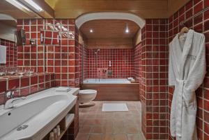 基茨比厄尔金谷瑞富酒店的红色瓷砖浴室设有浴缸和卫生间