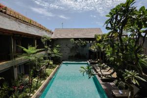 乌布Purana Suite Ubud的一座房子庭院中的游泳池