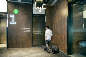 新加坡lyf Funan Singapore的手提箱走进电梯的人