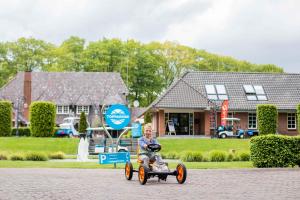 卢特伦拓普公园酒店 - 舍伦贝格地产的一名在街上骑玩具车的孩子