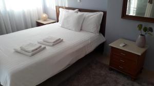 迈索隆吉翁Family apartments的卧室配有白色的床和2条毛巾