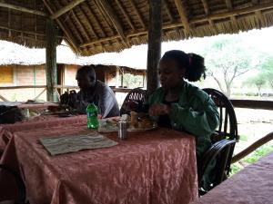 MailuaMailua Retreat的坐在餐桌旁吃食物的几个人