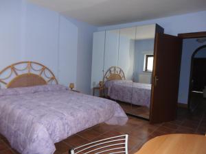 布拉恰诺Grazioso appartamento in villa的一间卧室配有两张床和镜子