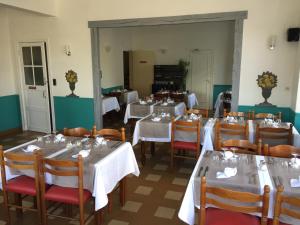 莱格勒西格尼酒店 的餐厅配有桌椅和白色的桌布