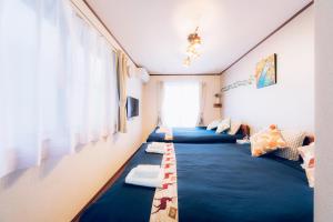 东京nestay suite tokyo shibuya的带3张蓝色毯子的床的房间