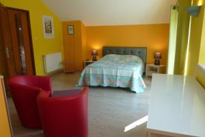 默兹河畔凡尔登VILLA CHANTAL的一间卧室配有一张床和两张红色椅子