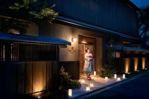 京都京都御所西侧君艾酒店的站在建筑物外的灯光下的妇女