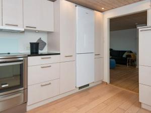埃斯比约4 person holiday home in Esbjerg V的一间厨房,配有白色的橱柜和一扇开放式门