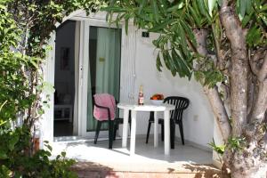 德尼亚Apartamento Oasis - Deniasol的庭院里的白色桌椅