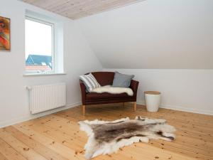 埃斯比约4 person holiday home in Esbjerg V的客厅配有椅子和毛皮地毯