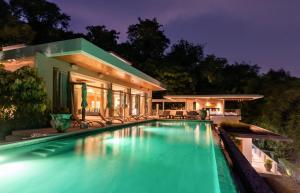 攀瓦海滩Villa Skyfall Thailand Phuket的夜间在房子前面的游泳池
