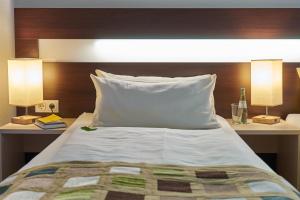 兰河畔马尔堡库斯佩赫尔酒店的一间卧室配有一张带两盏灯和床头板的床。