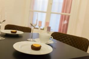 克拉根福Villa Gutenberg Residenz的一张桌子,上面放着一盘食物和酒杯