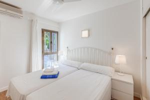 阿尔库迪亚港Ana Playasol的白色卧室内的一张白色床,设有窗户