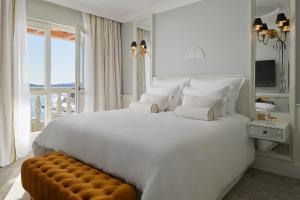 赫瓦尔Palace Elisabeth, Hvar Heritage Hotel的白色的卧室设有一张白色大床和一个窗户。