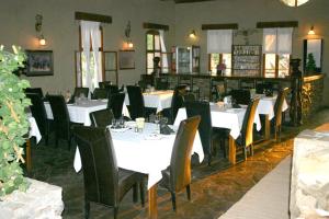 SesfonteinFort Sesfontein Lodge & Safaris的用餐室配有白色桌子和黑色椅子