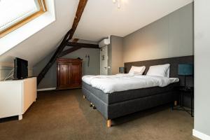 鲁尔蒙德De Pastorie Bed & Breakfast的一间卧室配有一张大床和电视