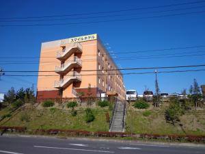 仙台IC仙台泉微笑酒店的一座位于山顶上的道路旁的建筑