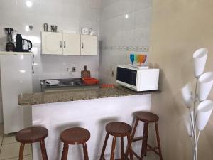南圣洛伦索Lindo Apto. Frente Praia (Cond. Dom Felippe)的厨房配有带凳子的柜台和微波炉