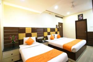 钦奈Saibala Grand Airport Hotel的一间酒店客房,房间内设有两张床