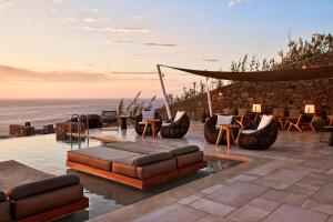 凯勒里瓦迪Mykonos Bliss - Cozy Suites, Adults Only Hotel的一个带沙发和椅子的庭院和大海
