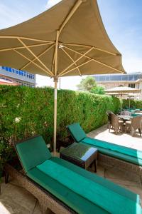 阿鲁沙SG Premium Resort的庭院配有遮阳伞、椅子和桌子。