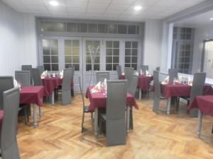Saint-PaulienHôtel des voyageurs的一间设有红色桌椅的用餐室