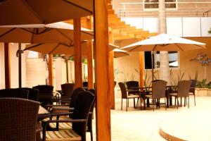 阿鲁沙SG Premium Resort的一个带桌椅和遮阳伞的户外庭院。