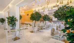 约阿尼纳Epirus Palace Congress & Spa的一间设有白色桌椅和树木的餐厅
