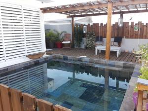 圣皮埃尔Maison TONGA piscine - jacuzzi confort的后院的游泳池,设有木甲板