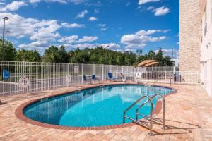 卫斯理堂Holiday Inn Express & Suites - Tampa North - Wesley Chapel, an IHG Hotel的游泳池周围设有围栏