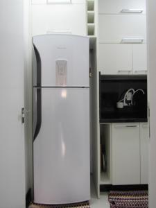 巴拉奈里奥-坎布里乌Apartamento Coral - 1 quadra do Mar的厨房配有白色的冰箱,厨房配有白色的橱柜