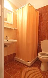 特尔斐赛比拉酒店的浴室设有橙色的淋浴帘和卫生间