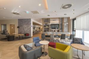 伍珀塔尔Holiday Inn Express - Wuppertal - Hauptbahnhof, an IHG Hotel的大堂设有桌椅和酒吧。